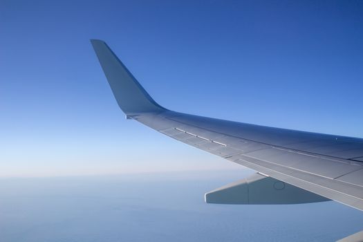 Airplane wing in the sky. View from a great height