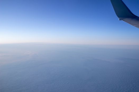 Airplane wing in the sky. View from a great height