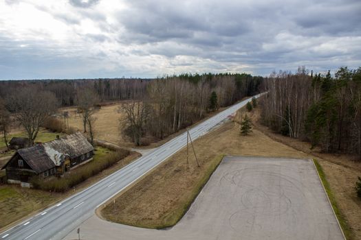 Aerial view from above of country road through the forest.