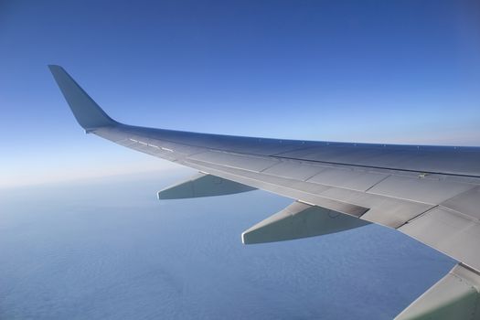 Airplane wing in the sky. View from a great height