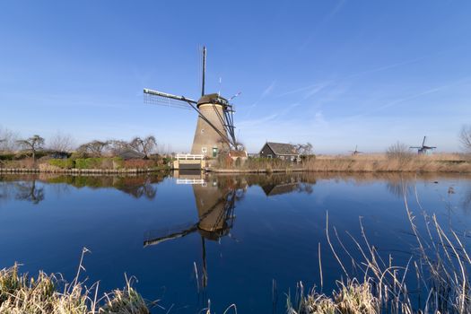 Early sunrise on the Unesco heritage windmill silhouette reflected on the calm water of the canal, Alblasserdam, Netherlands