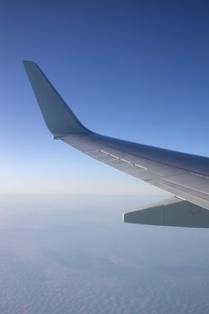 Airplane wing in the sky. View from a great height