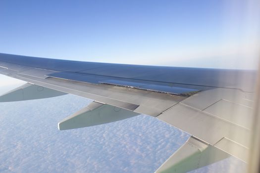 Airplane wing in the sky. View from a great height