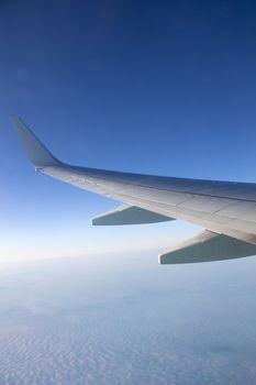 Airplane wing in the sky. View from a great height