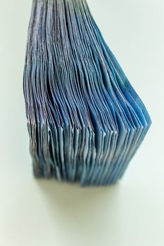 A bundle of 20 Euro banknotes and coins on a light background