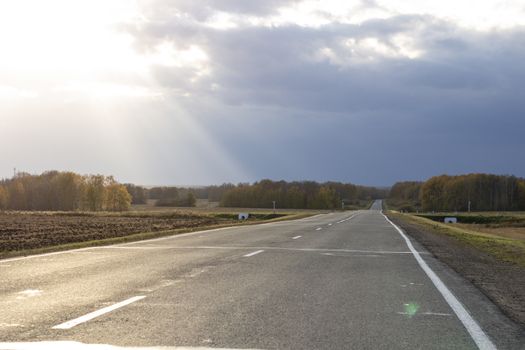 Large paved road in the middle of the field. Greater depth of field