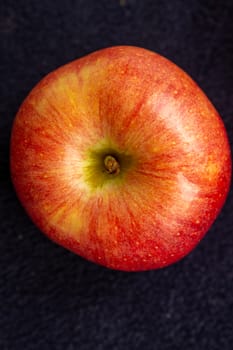 Three apples, one green and two red and yellow on a dark background.