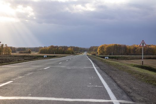 Large paved road in the middle of the field. Greater depth of field