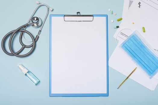 medical equipment mockup clipboard with stethoscope and drug, surgical mask on blue copy space background.