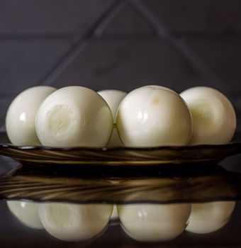 Peeled eggs on a black plate. Hard-boiled eggs. Cooking