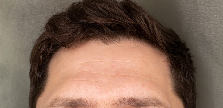 Forehead, upper part of a man's face. portrait of a young mans forehead and eyes with empty space