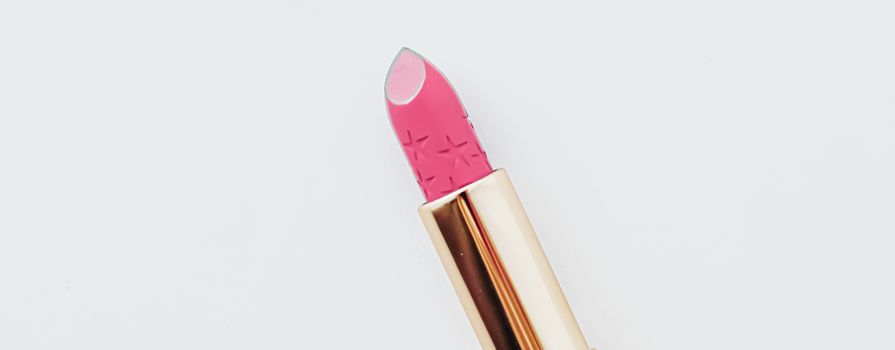 Luxury lipstick in a golden tube on white marble background, make-up and cosmetics concept