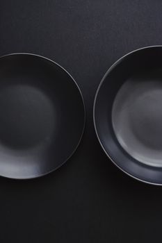 Empty plates on black background, premium dishware for holiday dinner, minimalistic design and diet concept