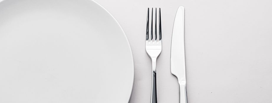 Empty plate and cutlery as mockup set on white background, top tableware for chef table decor and menu branding design