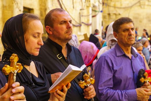 Jerusalem, Israel - April 6, 2018: Orthodox good Friday scene in the entry yard of the church of the holy sepulcher, with pilgrims praying. The old city of Jerusalem, Israel