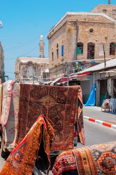 Jaffa, Israel - June 03, 2011: View of an alley with carpet store and mosque minaret, in the old city of Jaffa, now part of Tel-Aviv-Yafo, Israel