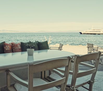 Empty restaurant by the Aegean sea and cruise boat, travel and nature, scene