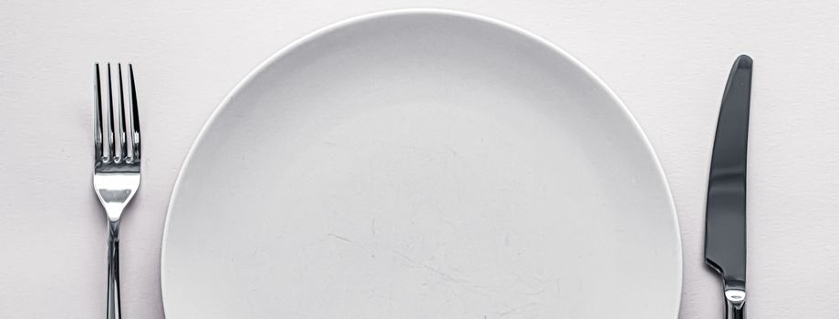 Empty plate and cutlery as mockup set on white background, top tableware for chef table decor and menu branding design