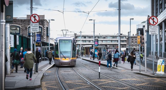 Dublin, Ireland - February 11, 2019: Passengers waiting for an electric tram in a downtown station on a winter day