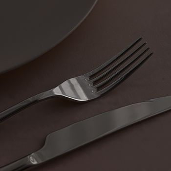 Empty plate and cutlery as mockup set on dark brown background, top tableware for chef table decor and menu branding design