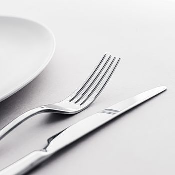 Empty plate and cutlery as mockup set on white background, top tableware for chef table decor and menu branding design