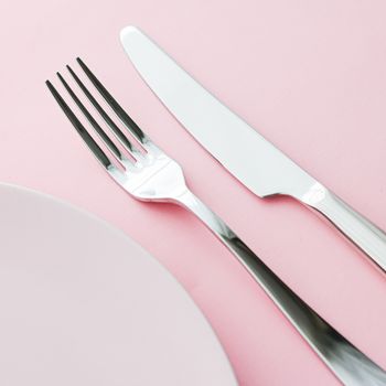 Empty plate and cutlery as mockup set on pink background, top tableware for chef table decor and menu branding design