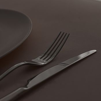 Empty plate and cutlery as mockup set on dark brown background, top tableware for chef table decor and menu branding design