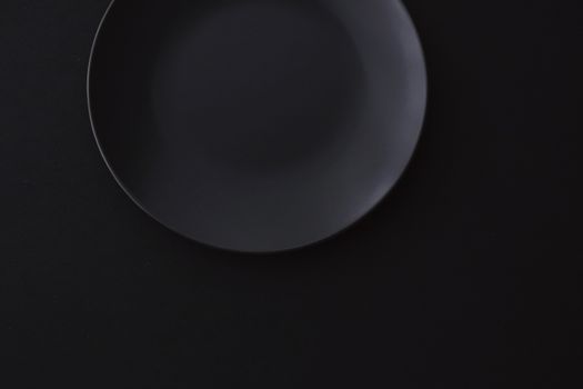 Empty plates on black background, premium dishware for holiday dinner, minimalistic design and diet concept