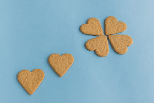 Breakfast. Close-up of heart shaped cookies like a flower petals.. Blue background. Copy space