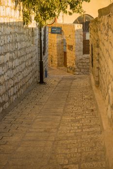 SAFED, ISRAEL - SEPTEMBER 14, 2016: An alley in the Jewish quarter of the old city, with the Abuhav Synagogue sign, in Safed (Tzfat), Israel