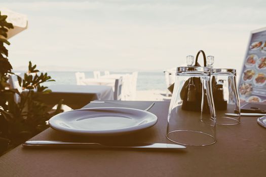 Empty restaurant by the Aegean sea and cruise boat, travel and nature, scene