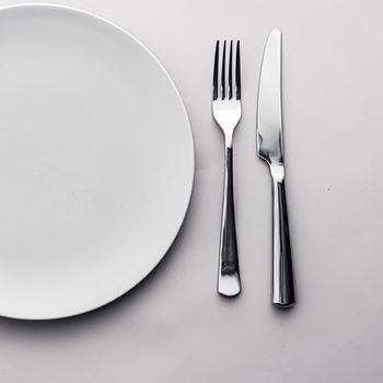 Empty plate and cutlery as mockup set on white background, top tableware for chef table decor and menu branding design