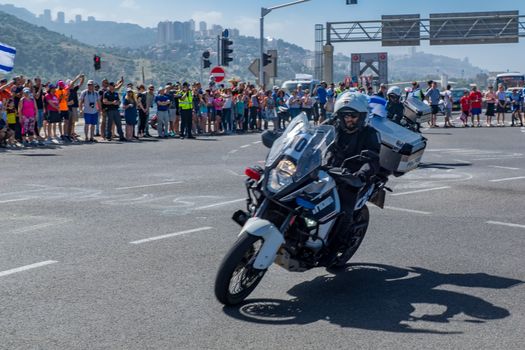 YAGUR, ISRAEL - MAY 05, 2018: Spectators wait for stage 2 of 2018 Giro d Italia, with police motorcyclists, in Yagur, Israel