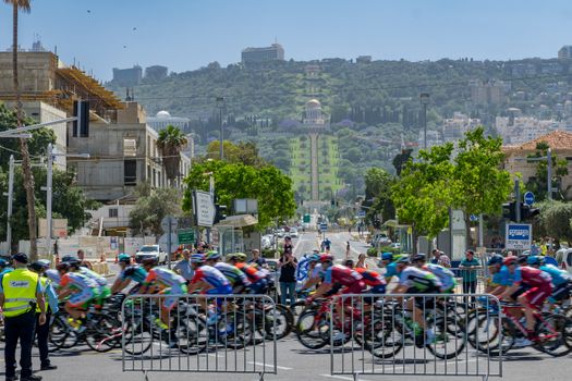 HAIFA, ISRAEL - MAY 05, 2018: Scene of stage 2 of 2018 Giro d Italia, with cyclists and spectators, and the German Colony, Bahai gardens and shrine in the background. Haifa, Israel