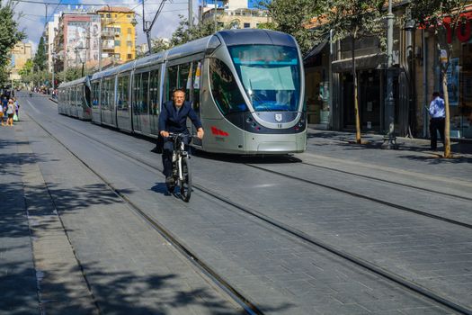 JERUSALEM, ISRAEL - SEPTEMBER 23, 2016: Scene of Yafo Street, with a tram, cyclist and other locals and visitors. In Jerusalem, Israel