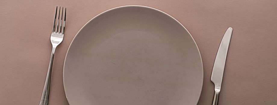 Empty plate and cutlery as mockup set on brown background, top tableware for chef table decor and menu branding design