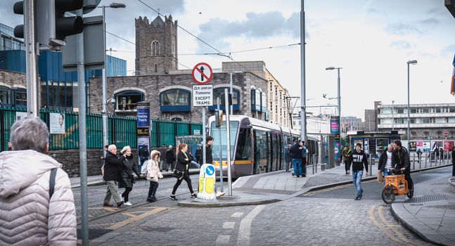 Dublin, Ireland - February 11, 2019: Passengers waiting for an electric tram in a downtown station on a winter day