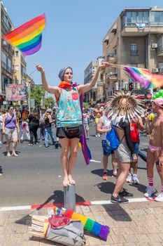 TEL-AVIV, ISRAEL - JUNE 08, 2018: Rainbow flags seller, and other participants, take part in the annual pride parade of the LGBT community, in Tel-Aviv, Israel