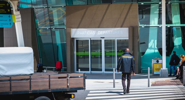 Faro, Portugal - May 3, 2018: Security guard supervising the entrance of Faro International Airport on a spring day