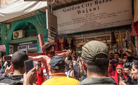 JERUSALEM - APRIL 18, 2014: A group of American actors re-enchant the crucifixion of Jesus Christ along the stations of Via Dolorosa, on Good Friday, in the old city of Jerusalem, Israel