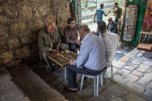 JERUSALEM - APRIL 18, 2014: Typical street scene of backgammon players, in the old city of Jerusalem, Israel