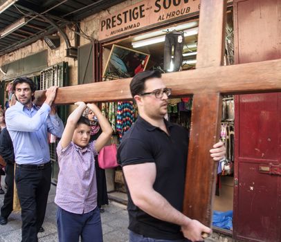 JERUSALEM - APRIL 18, 2014: Pilgrims from all over the world commemorating the crucifixion of Jesus Christ by carrying a cross along via dolorosa, on good Friday, in the old city of Jerusalem, Israel