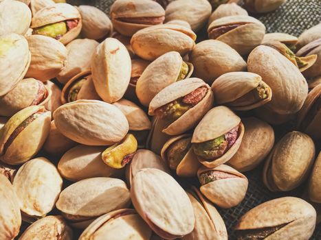 Pistachio nuts on rustic linen background, food and nutrition