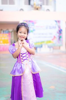 Portrait of cute smiling little girl in princess costume standing in school