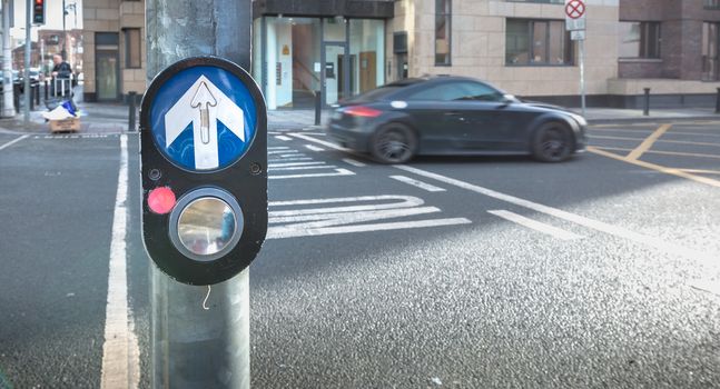 Dublin, Ireland - February 11, 2019: Button to activate pedestrian crossing on the road on a pedestrian crossing in the city center on a winter day