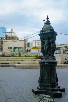 HAIFA, ISRAEL - DECEMBER 08, 2016: Scene of Paris square in downtown, with locals and visitors, the Maronite Cathedral of St. Louis the King, HaNeviim tower, and other buildings, in Haifa, Israel