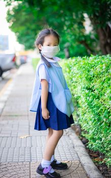 thai girl student wear a mask against PM 2.5 air pollution before going to school