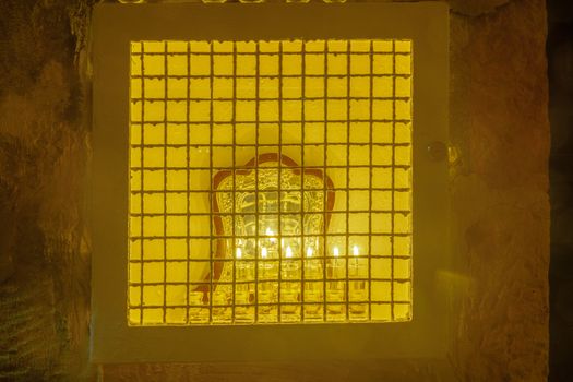 JERUSALEM, ISRAEL - DECEMBER 29, 2016: Traditional Menorah (Hanukkah Lamp) with olive oil candles, in the Jewish quarter, Jerusalem Old City, Israel. The text is the Hanukkah Blessings