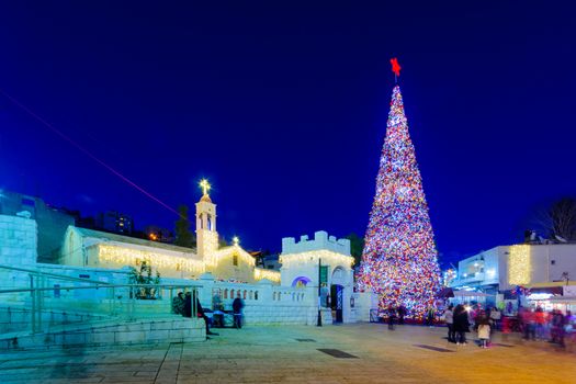 NAZARETH, ISRAEL - DECEMBER 20, 2016: Christmas scene of Mary Well square, with the Greek Orthodox Church of the Annunciation, a Christmas tree, locals and tourists, in Nazareth, Israel