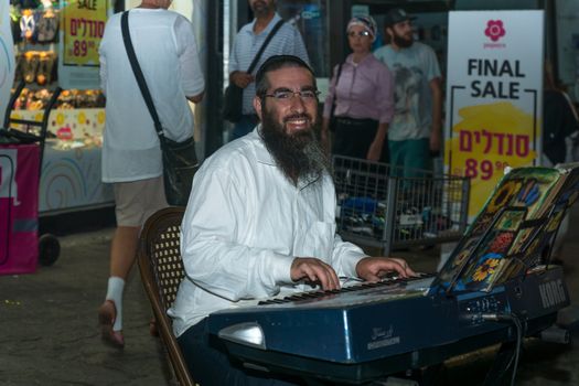 Safed, Israel - August 14, 2018: Scene of the Klezmer Festival, with street musician and crowd, in Safed (Tzfat), Israel. Its the 31st annual traditional Jewish festival in the public streets of Safed